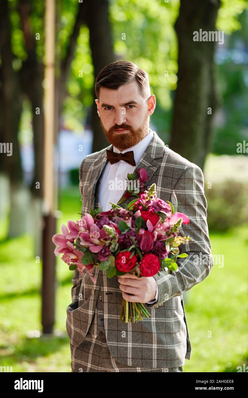 Homme vêtu costume élégant Holding Bouquet de fleurs Photo Stock - Alamy