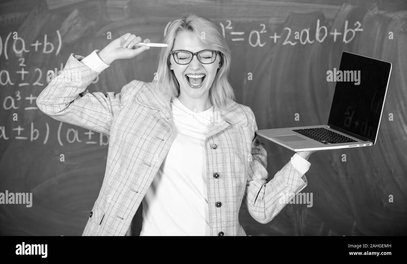 Dame intelligente smart éducateur avec ordinateur portable moderne tableau internet surf arrière-plan. Idée sur son esprit. Les technologies numériques concept. Enseignante portent des lunettes est titulaire d'ordinateur portable Internet surf. Banque D'Images