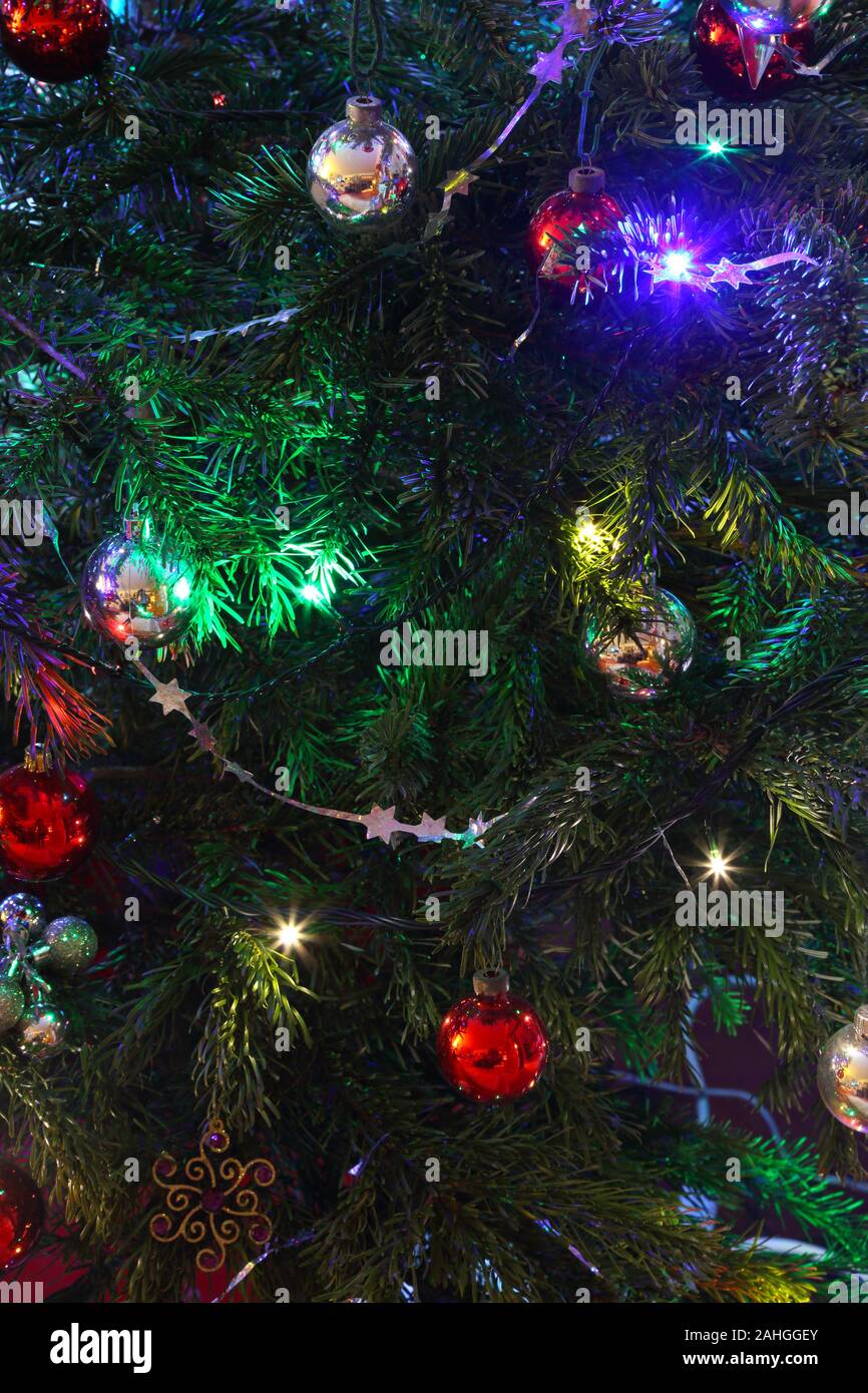 Close-up d'une partie d'un arbre de Noël avec des décorations, boules de Noël, guirlandes, étoiles, et fairy lights, Haslemere, Surrey, UK. Banque D'Images