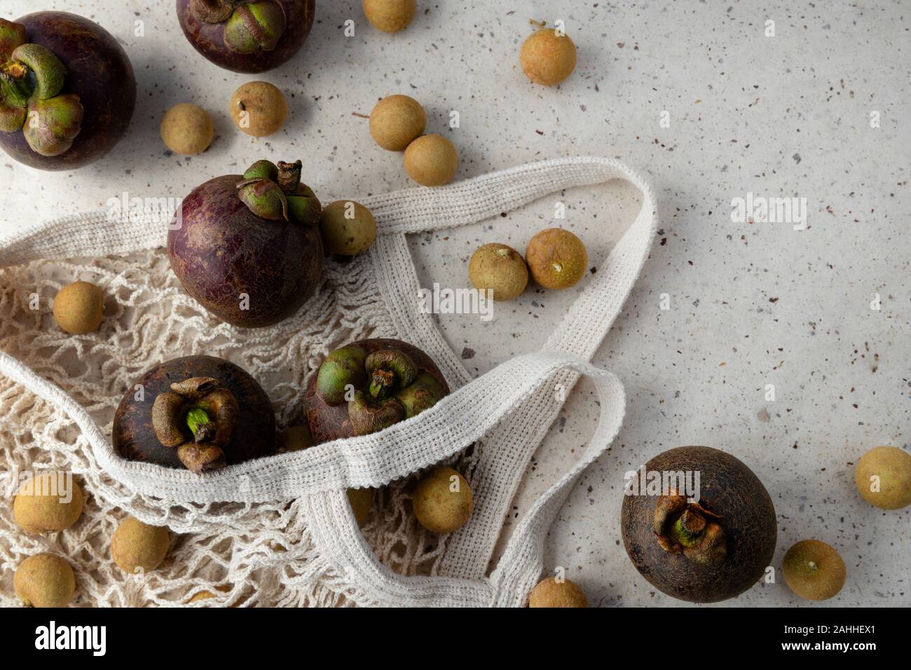 Télévision avec composition laïcs et mangoustan frais mûrs fruits longane dans string bad sur fond de papier. Zéro déchets en plastique shopping concept libre. Banque D'Images