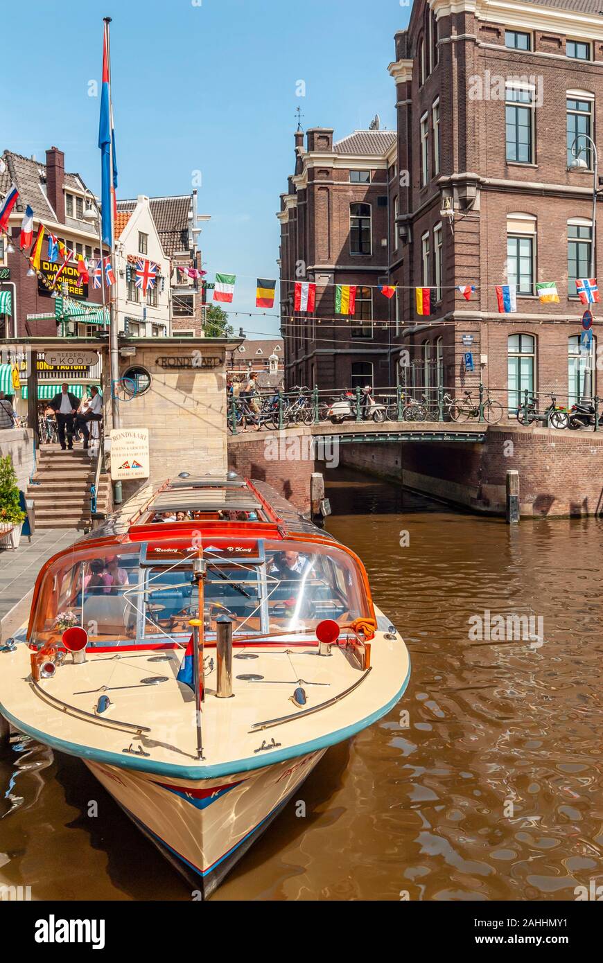 Des bateaux touristiques typiques dans un canal d'eau dans le centre-ville d'Amsterdam, Pays-Bas Banque D'Images