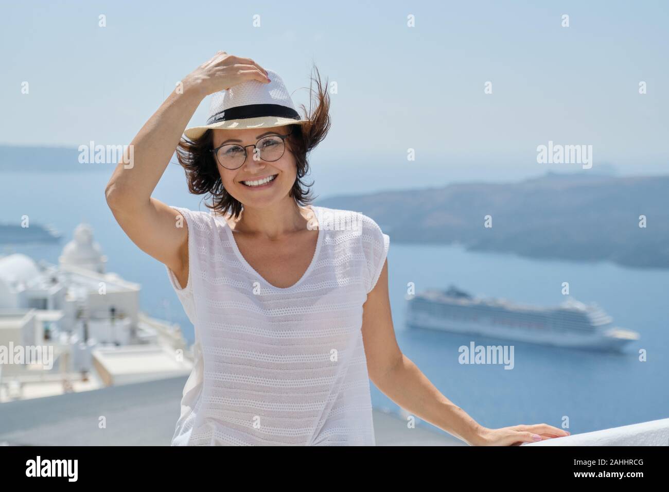 Portrait de femme d'âge moyen voyageant sur croisière de luxe en Méditerranée. Female looking at camera sur l'île de Santorin, copy space Banque D'Images