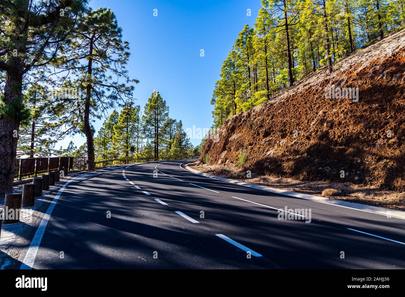 Espagne, Ténérife, courbes de rêve route asphaltée à côté green de conifères dans les montagnes jusqu'au mont Teide, un volcan impressionnant Banque D'Images