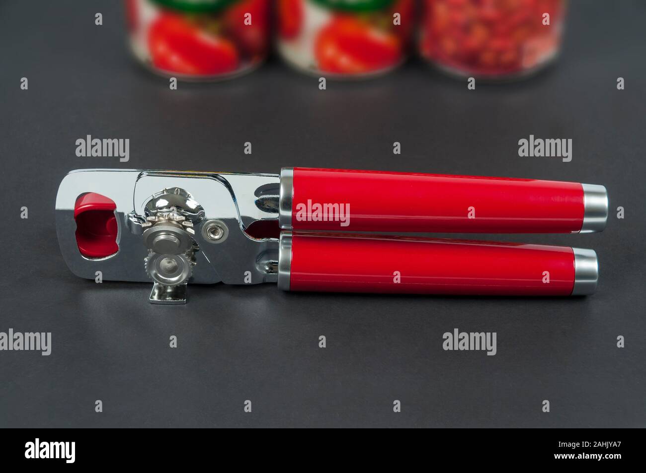 Un Red-Handled KitchenAid manuel peut et ouvre-bouteille. Banque D'Images