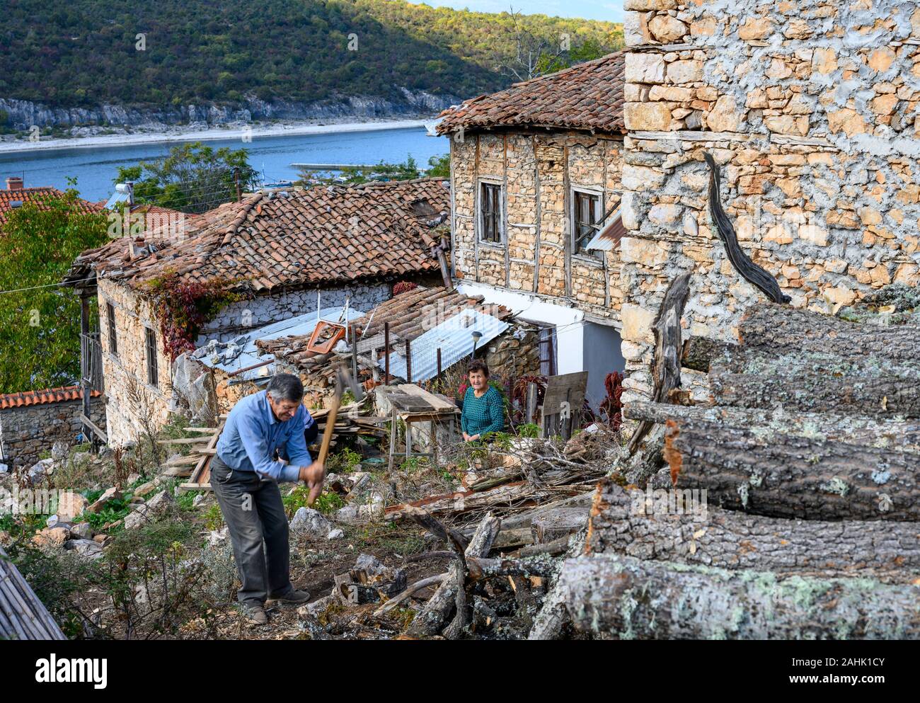 Couper le bois pour l'hiver dans le petit village de pêcheurs sur le lac Prespa Psarades étonnant avec de la Macédoine, la Grèce du Nord. Banque D'Images