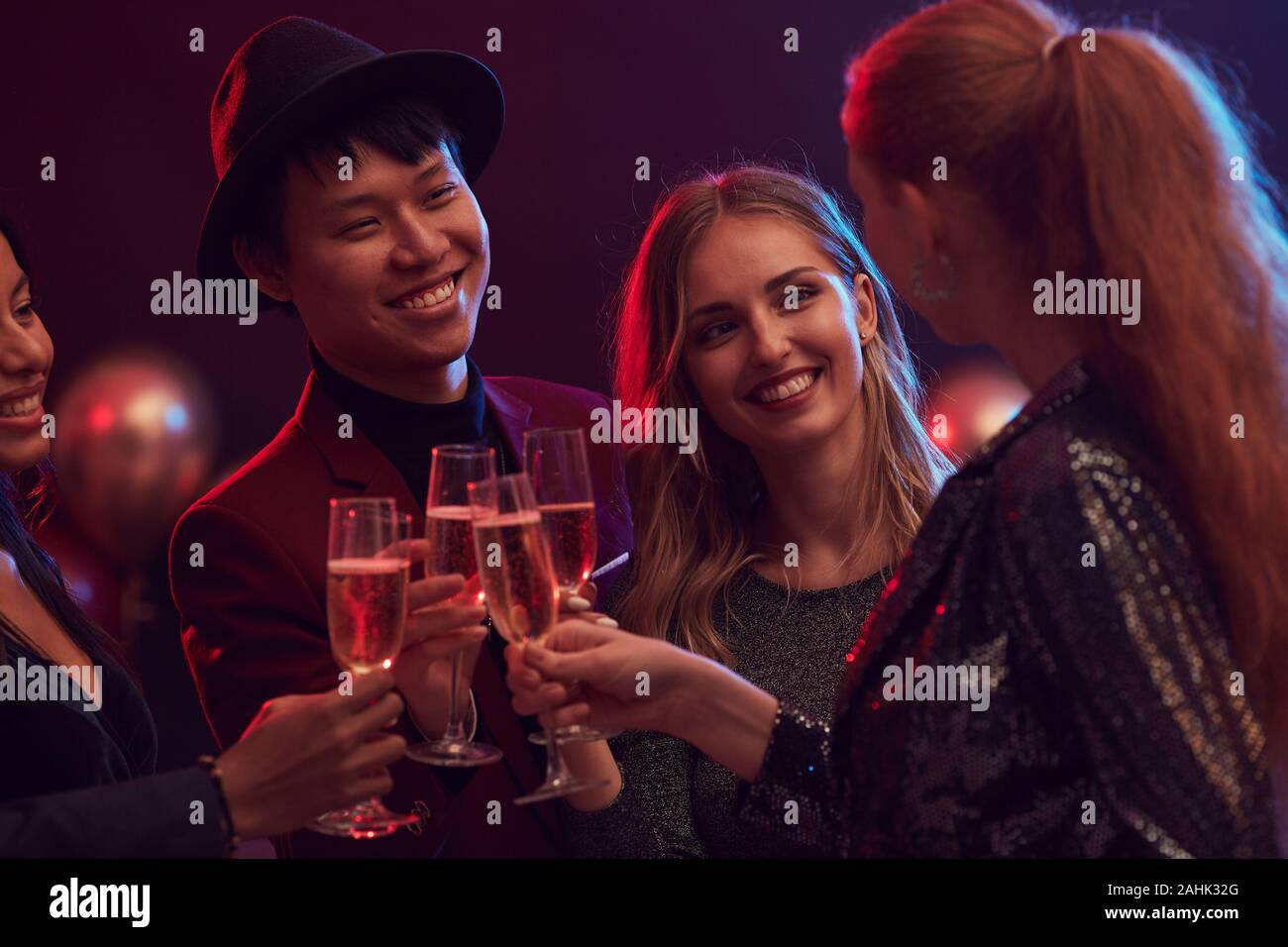 Groupe multi-ethnique de personnes tintement des verres de champagne tout en admirant la partie en discothèque ou restaurant, copy space Banque D'Images