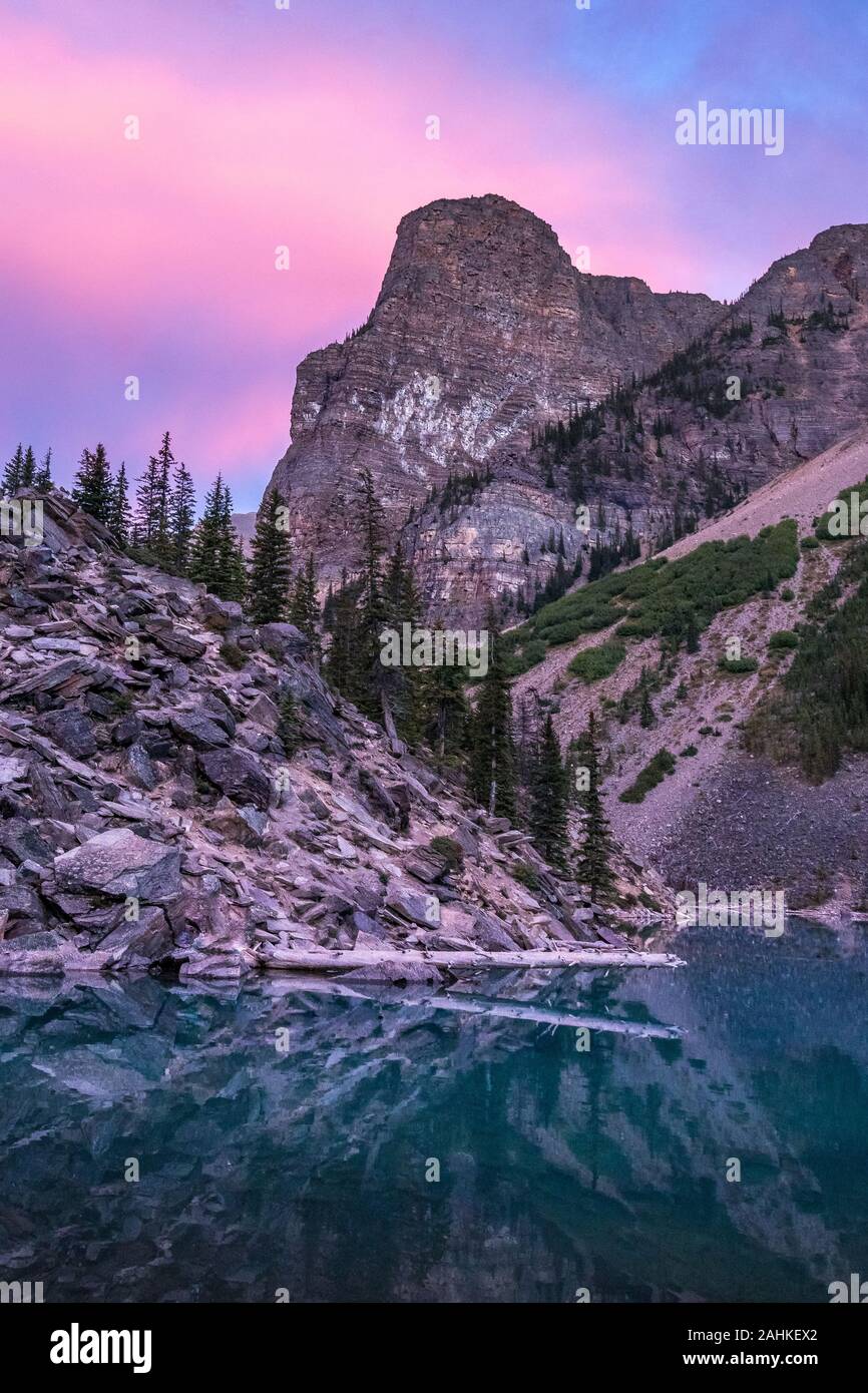 Vue du lac Moraine colorés amas après le coucher du soleil avec des reflets sur l'eau, Banff National Park, Alberta, Canada Banque D'Images