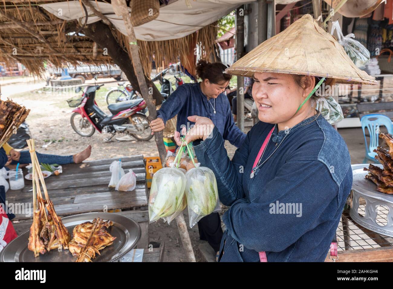 Persn vendant de la nourriture aux voyageurs à bord de la stalle, Pakse, Laos Banque D'Images