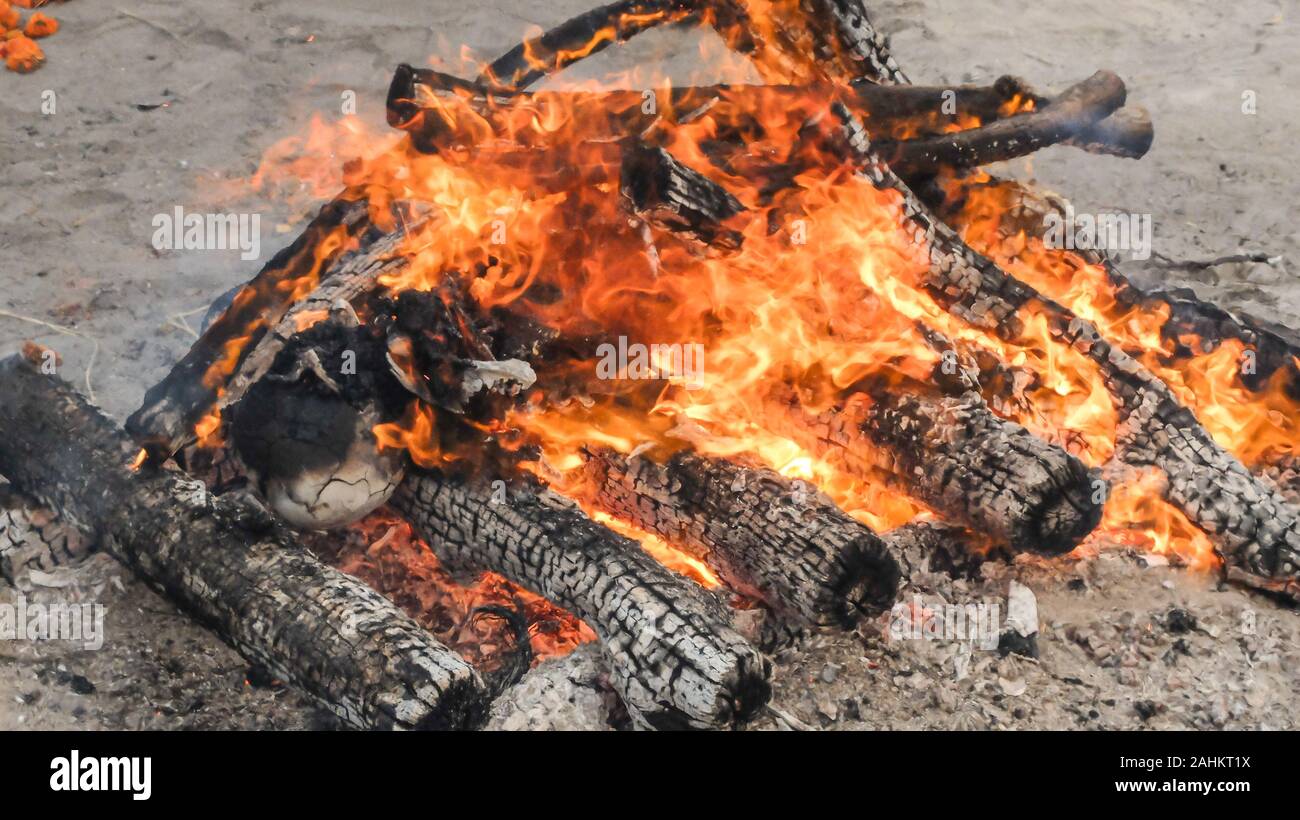 Restes humains peut à peine être vu comme du feu de bois brûle pendant le rituel de la crémation commune largement pratiquée dans toute l'Inde. Banque D'Images