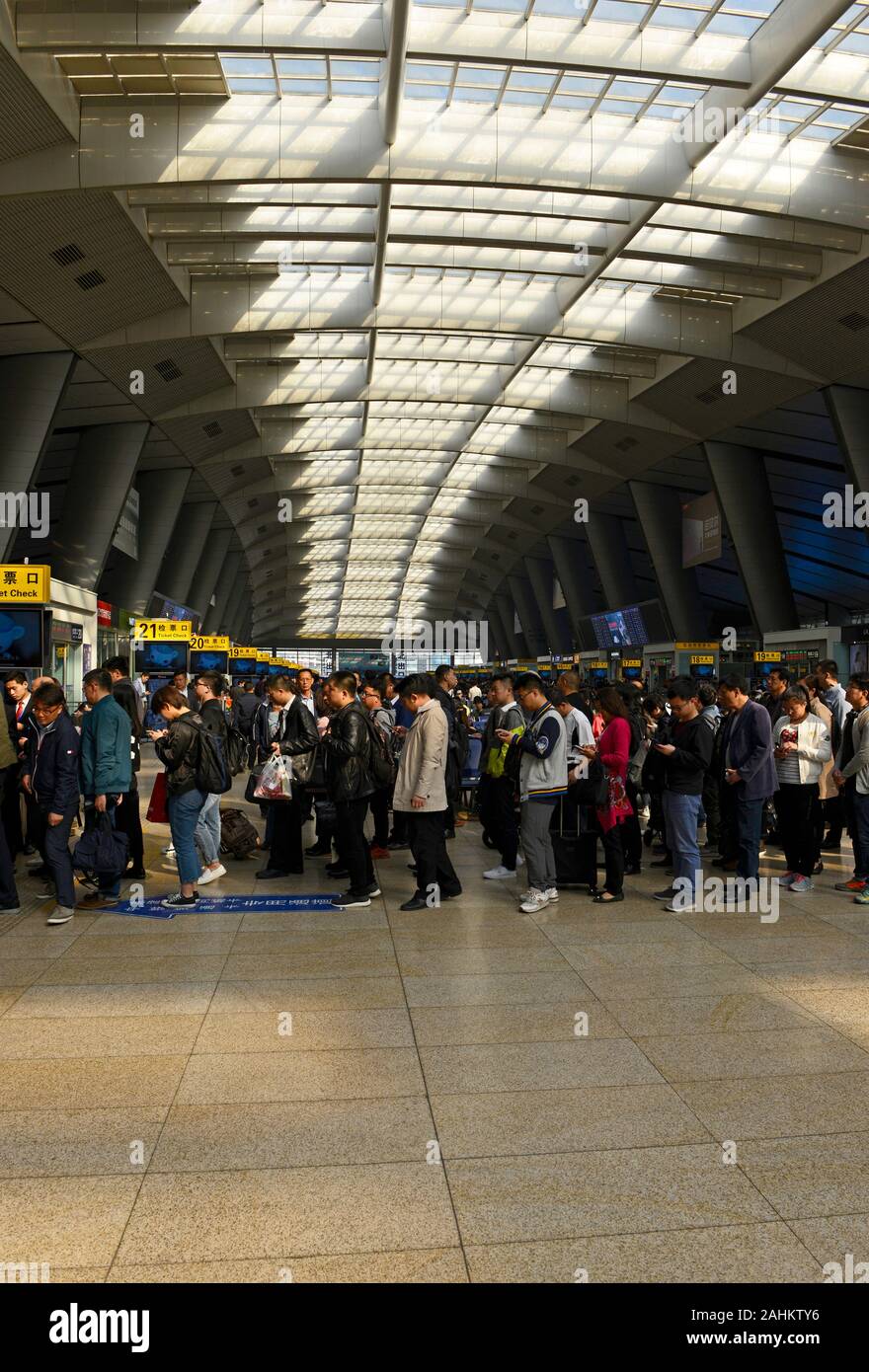 File d'attente des voyageurs à passer à travers les obstacles à des plates-formes pour un service haute vitesse à proximité de Tianjin à la gare sud de Beijing, Beijing, Chine Banque D'Images