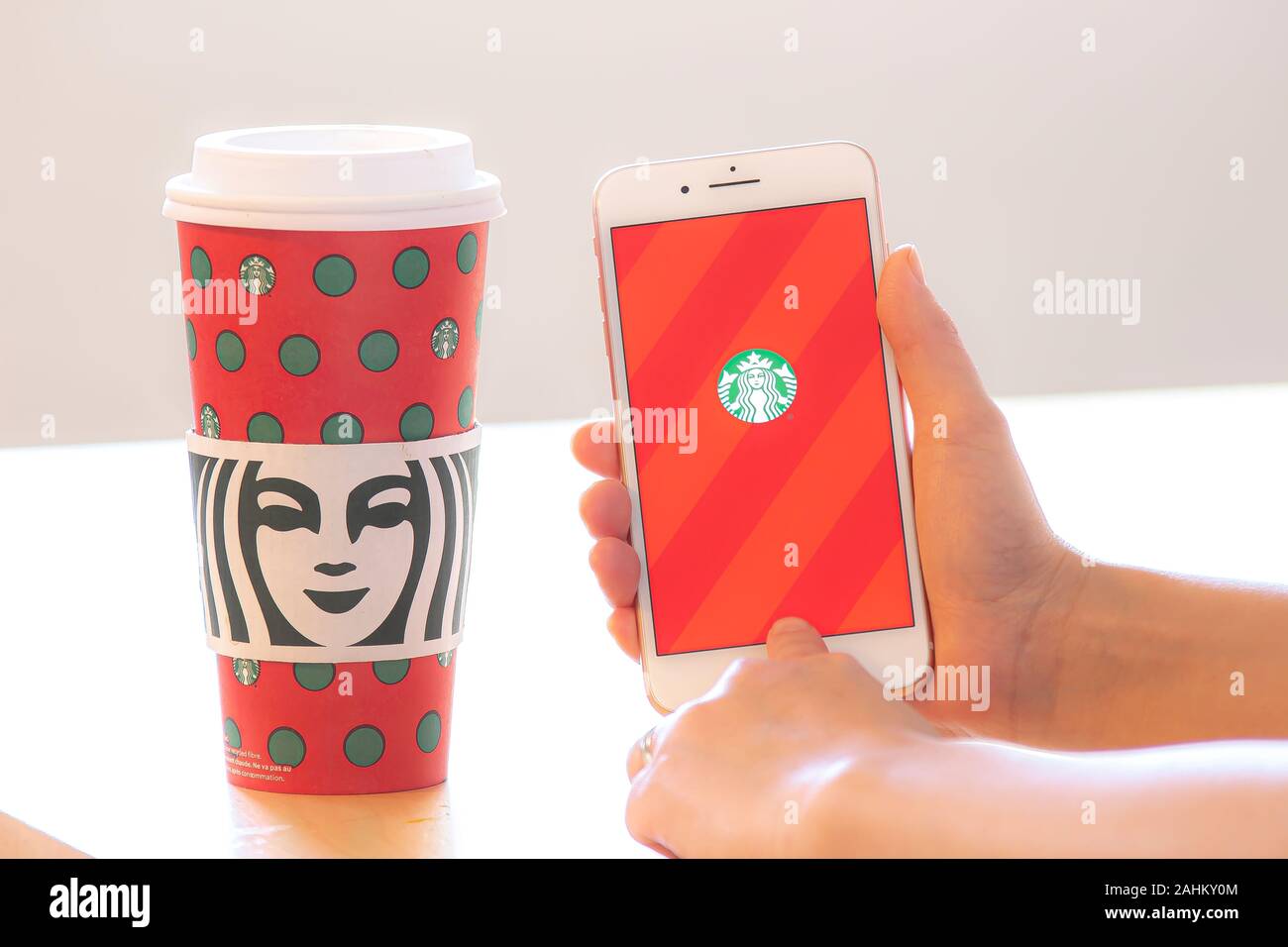 Calgary (Alberta). Canada 28 Déc 2019. Une personne titulaire d'un iPhone à l'aide de l'application Starbucks avec un café au cours de Noël. Guy Starbucks' a passé 22 ans Banque D'Images