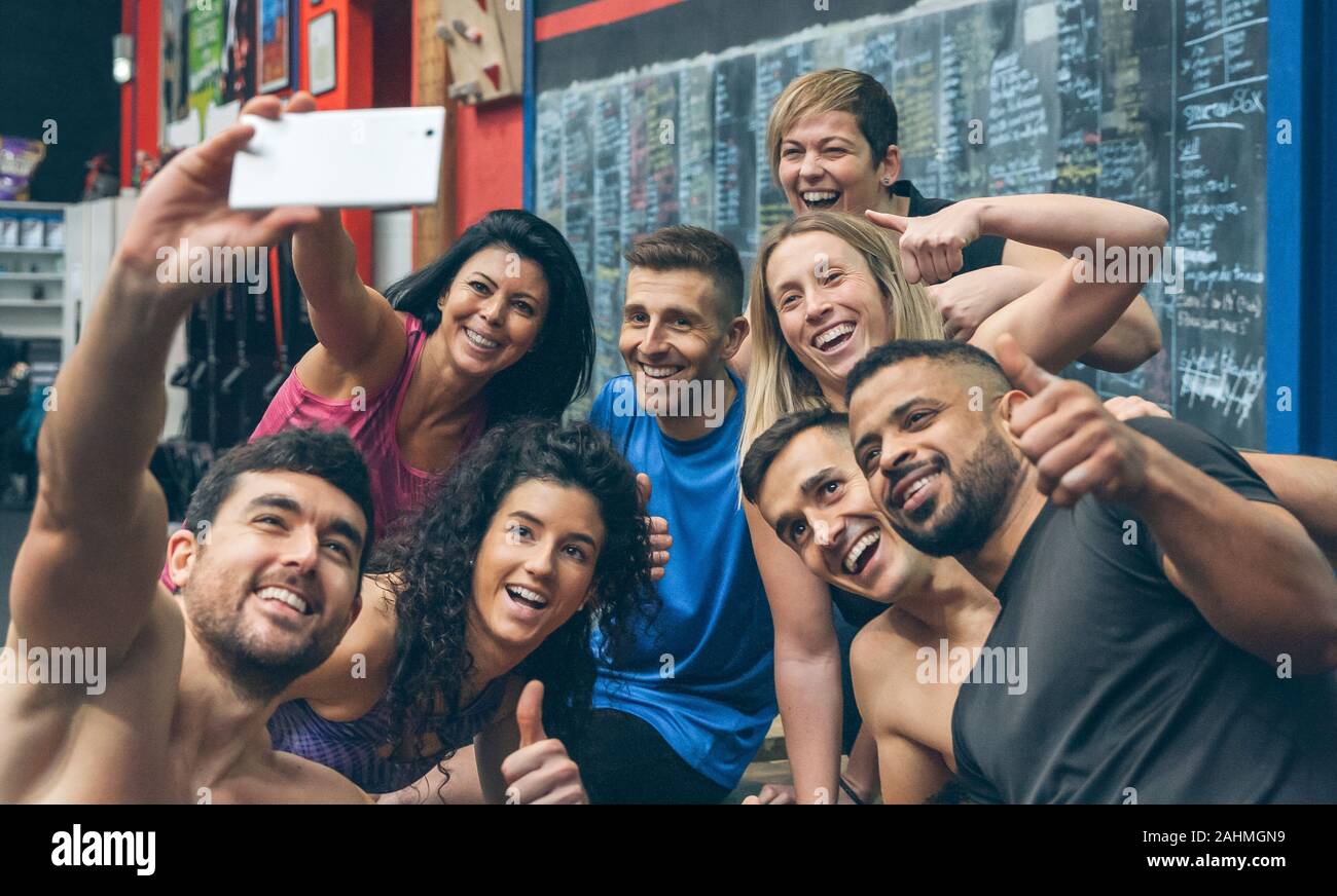 Les athlètes de prendre un mobile avec les selfies dans la salle de sport Banque D'Images