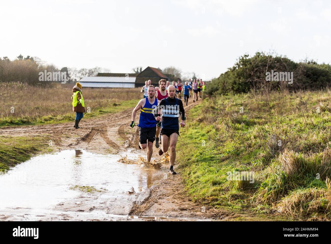 Sutton, Suffolk, UK 15 décembre 2019 : un adultes de plus de 18 course cross-country course à travers un cours de campagne boueux Banque D'Images