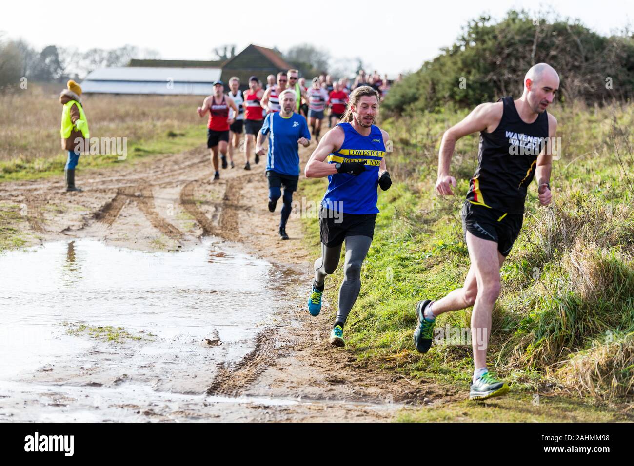 Sutton, Suffolk, UK 15 décembre 2019 : un adultes de plus de 18 course cross-country course à travers un cours de campagne boueux Banque D'Images