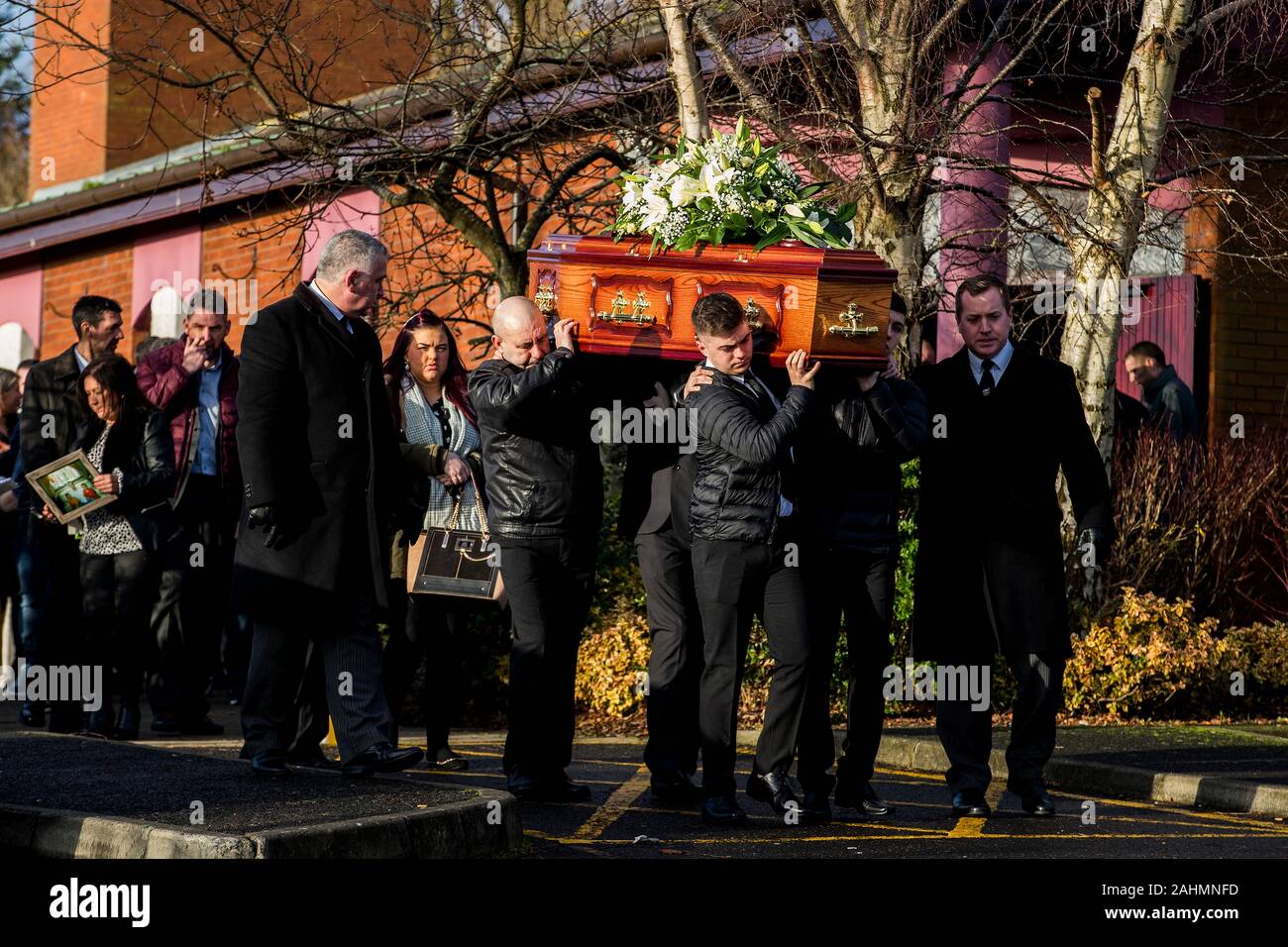 Les porteurs portent le cercueil de poignardée Joseph (Joe) Dutton à la suite d'une messe de requiem à St Oliver Plunkett's Church dans l'ouest de Belfast. M. Dutton, 47, et Frances Murray, 37 ans, est mort après avoir été poignardé dans un appartement à Kinnaird Fermer dans le nord de la ville le 22 décembre. Un homme a été arrêté et accusé de la double meurtre. Banque D'Images