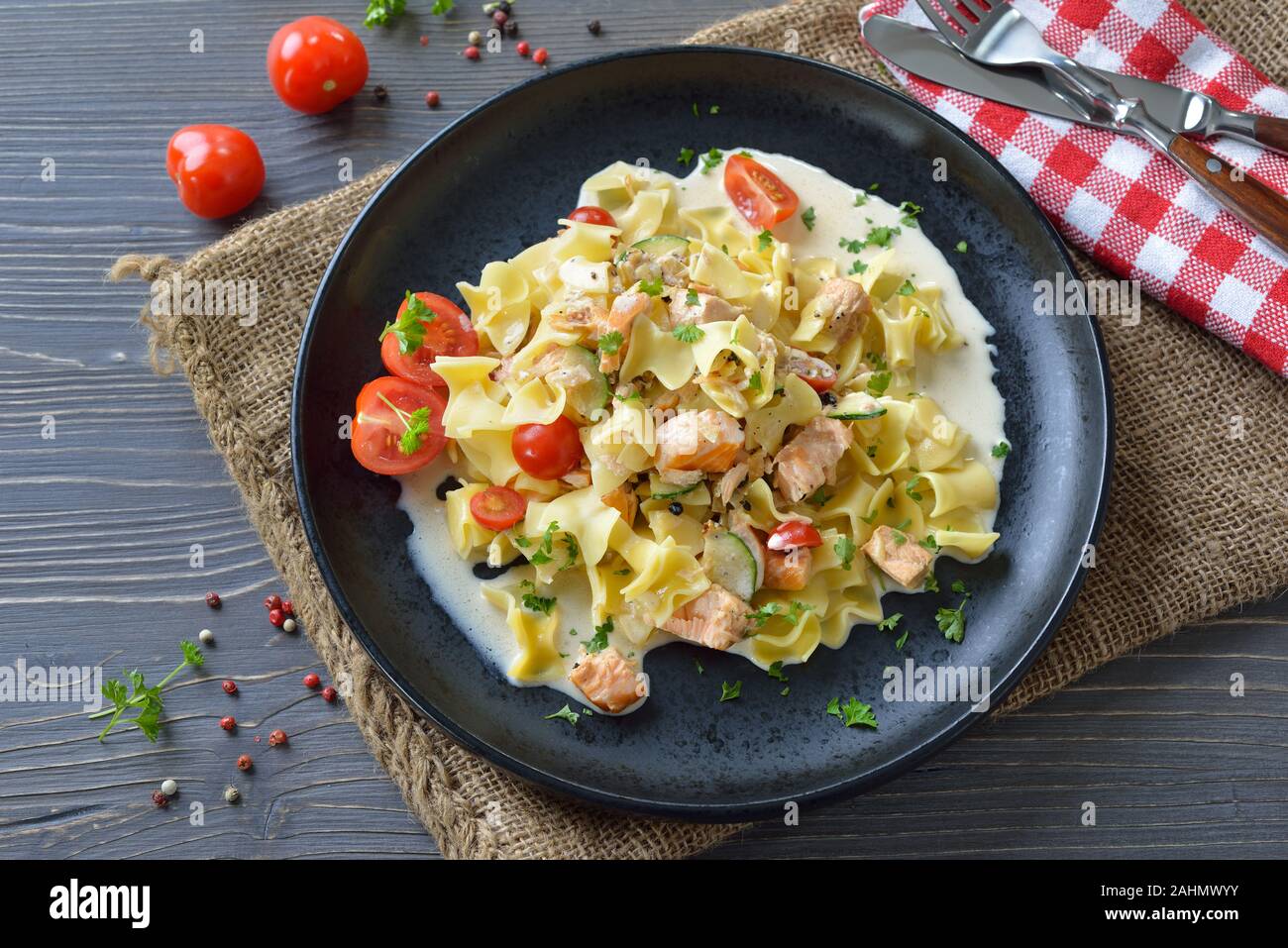 Repas autrichien avec pâtes typiques et saumon fumé avec sauce crémeuse, servis sur une plaque noire Banque D'Images