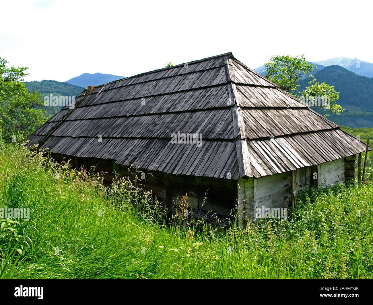 Maison gutsul abandonnés et oubliés dans des montagnes vertes. L'été pittoresque paysage de montagne dans l'Est des Carpates. Un vieux bâtiment gutsul Banque D'Images