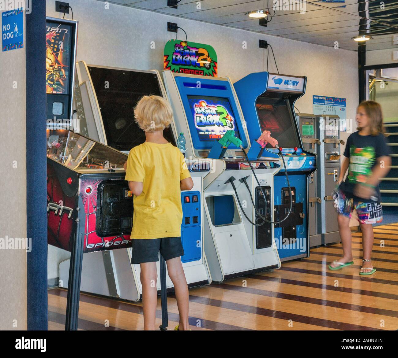 Mer Méditerranée - Juillet 23, 2019 : Garçon et fille joue sur les jeux de combat arcade machine à sous sur Moby ferry navire à passagers. Banque D'Images