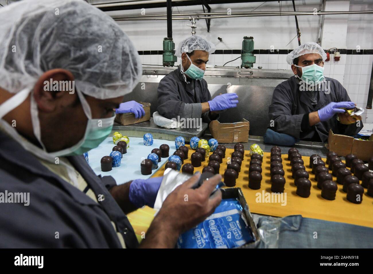 La ville de Gaza, bande de Gaza, territoire palestinien. 31 Dec, 2019. Les travailleurs palestiniens, préparer les bonbons à la vanille connu comme ''Ras el-Abed ou Shatawi'' dans l'usine de douce dans la ville de Gaza le 31 décembre 2019. Lundi, les autorités israéliennes ont autorisé l'exportation de ''Ras El-Abed'' candy connu comme ''hatawi'''' de la bande de Gaza vers les états du Golfe : Crédit Ashraf Amra/APA/Images/fil ZUMA Alamy Live News Banque D'Images