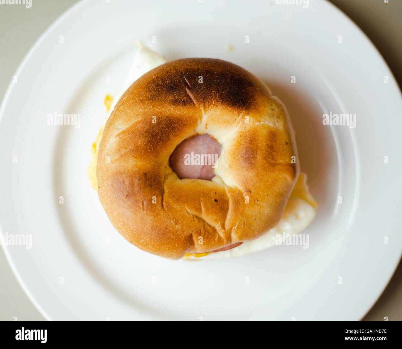 Oeufs, bacon canadien, Bagel Breakfast Sandwich sur haut en bas de la plaque Banque D'Images