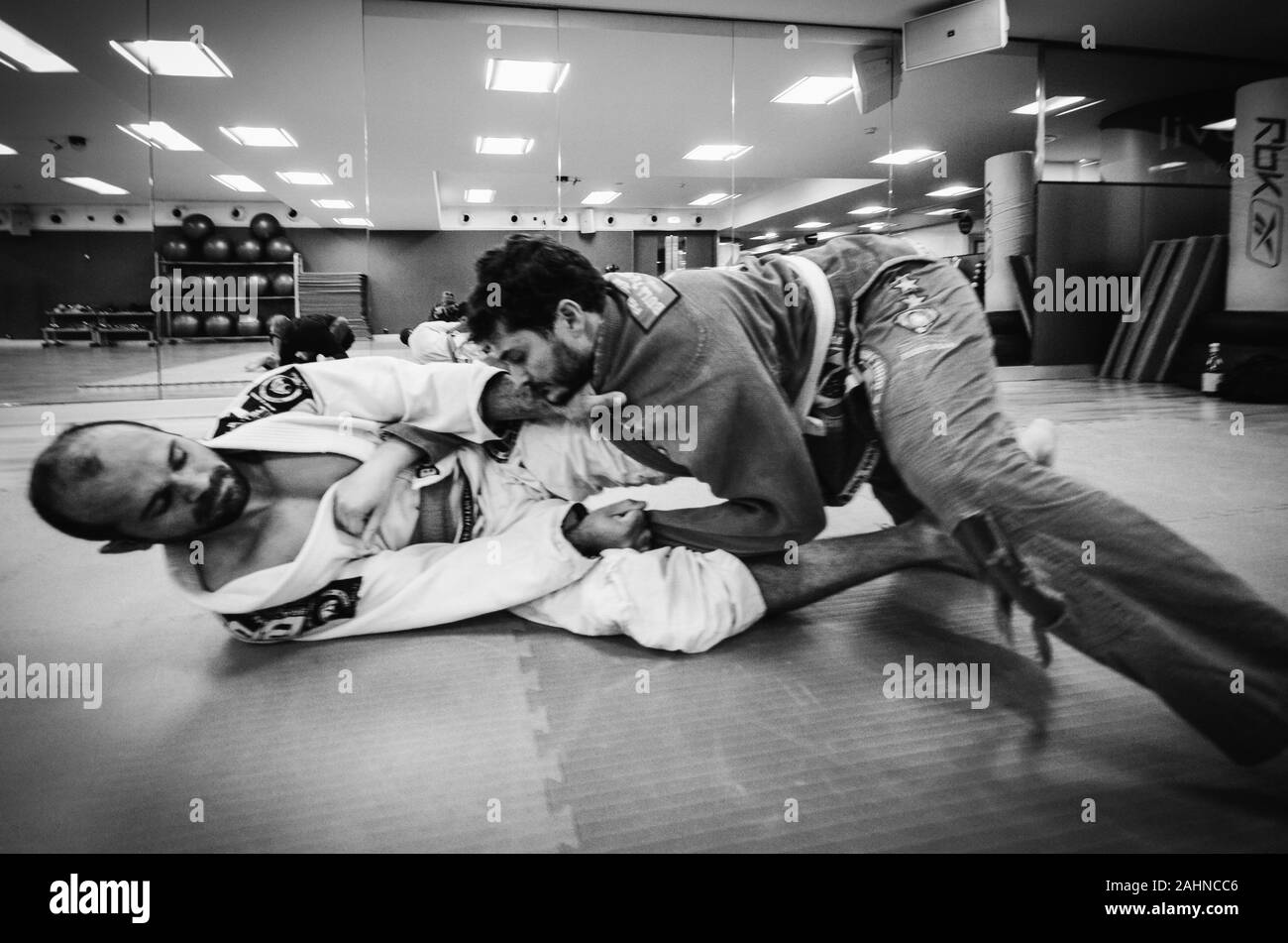 Deux jeunes hommes pratique en jiu-jitsu brésilien, grappling combat un type d'arts martiaux avec un kimono gi - non monté Banque D'Images