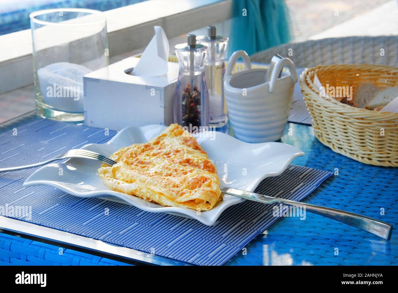 Omelette au bacon dans un restaurant, petit-déjeuner traditionnel. Couteau et fourchette de la plaque. Mettre en place le mode de vie. Le petit-déjeuner sur la table. Banque D'Images