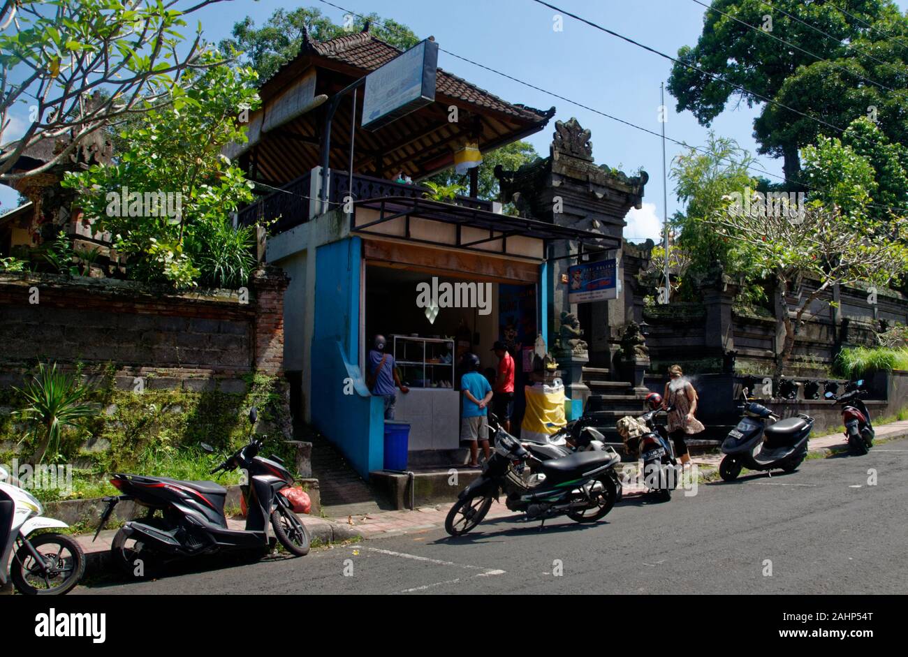 Motos garées à l'extérieur de l'explosion d'une boutique où les gens achètent des aliments et boissons, Ubud, Bali, Indonésie Banque D'Images