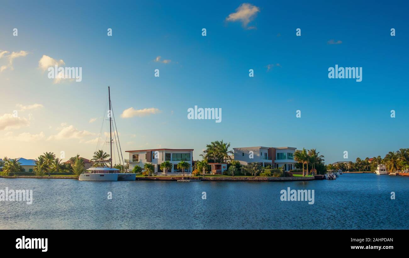 Grand Cayman, îles Caïmans, Jan 2019, bateau amarré dans une zone résidentielle au coucher du soleil sur un canal menant à la mer des Caraïbes dans la région de West Bay Banque D'Images
