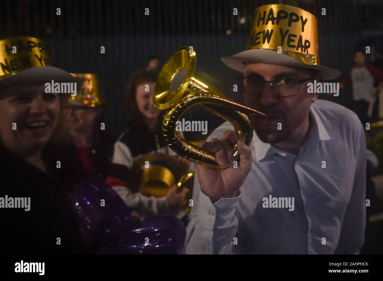 Jakarta, Indonésie. 31 Dec, 2019. Un homme souffle une trompette de papier dans la rue pour célébrer la nouvelle année à venir à Jakarta, Indonésie, le 31 décembre 2019. Ti'Kuncahya Crédit : B./Xinhua/Alamy Live News Banque D'Images