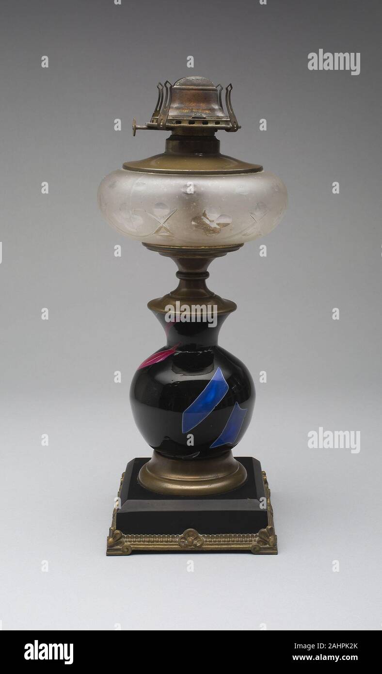 Frederick S. Shirley. Lampe en verre sicilien. 1878. United States. Cette lampe en verre est un exemple du premier groupe de verrerie artistique breveté par le Mont Washington Glass Company. Frederick S. Shirley, un verrier et formé, a présenté la ligne de Sicile, qui a été inspirée par les fouilles de la ville antique de Pompéi dans les années 1860 et inclus les éléments chimiques de lave volcanique dans ses ingrédients. Shirley a également mis au point le processus de fusion de séparer des éclats de verre dans le corps de ses marchandises sicilien, résultant en l'aspect insolite de ces navires aux couleurs vives. Banque D'Images