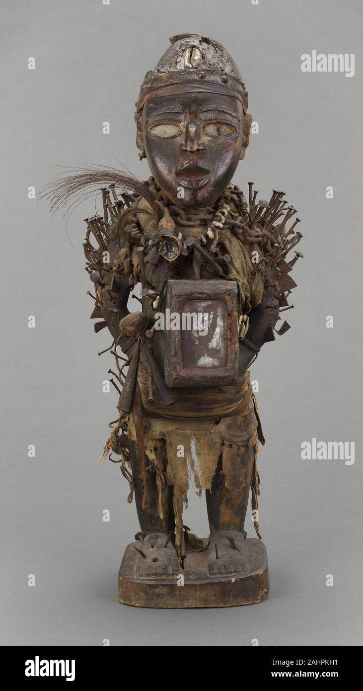 L'IVL. La Figure masculine (nkisi nkondi). 1801-1875. République du Congo (objet fait en Afrique), (Objet fait en). Bois, métal, verre, tissu, fibre, cauris, os, cuir, gourd, et de plumes, le terme fait référence à nkisi spirit-investi les objets qui ont eu le pouvoir avec les médicaments et les ingrédients magiques appelée bilongo. Dans le cas de cette figure masculine, le bilongo sont enfermés dans le capuchon sur la tête et dans le miroir de paquets de résine sur l'abdomen. Le nom fait référence à la figure nkondi sa capacité à traquer et punir les malfaiteurs. Un clou ou une lame a été conduit dans la figure pour inviter l'inha Banque D'Images