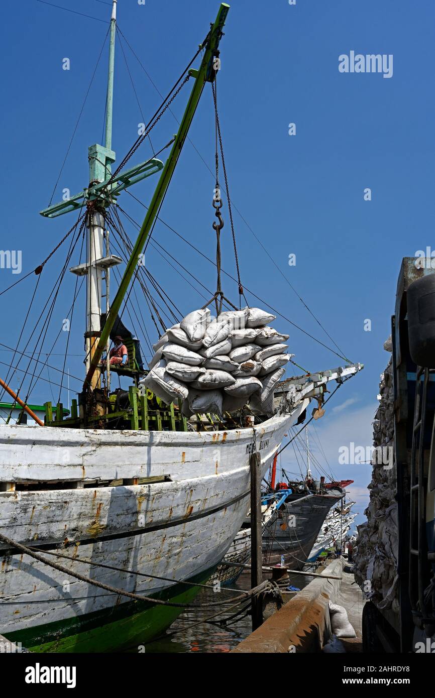 Jakarta, Indonésie - 2019.12.18 : sortie des marchandises dans des sacs de prahu pinisi en bois (kapal layar motor klm) dans des camions au Port Sunda Kelapa Banque D'Images