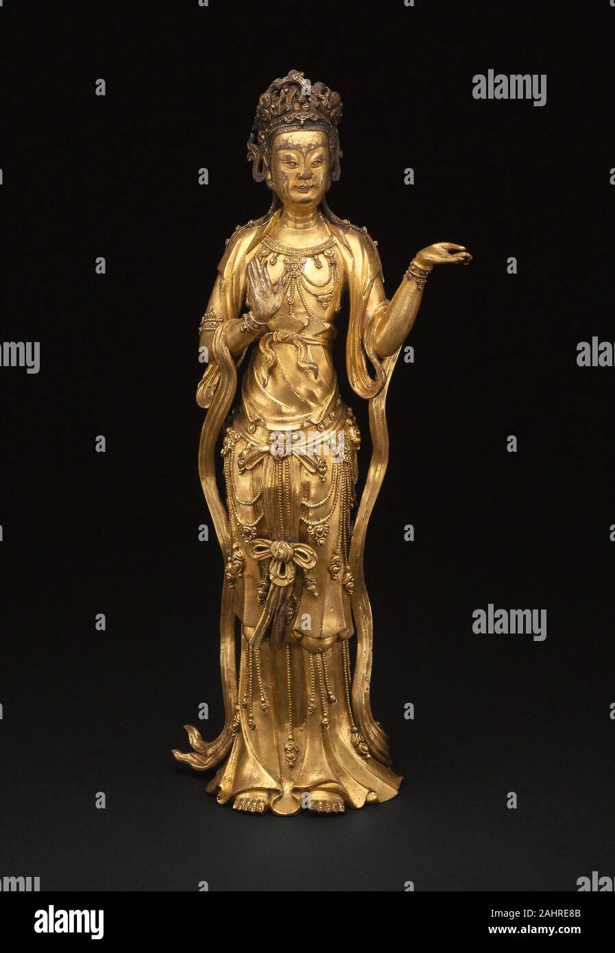 Avalokiteshvara (Guanyin). 1350-1400. La Chine. Alliage de cuivre doré dans ses proportions willowy, ainsi que les traits du visage et l'habillement, cette image illustre les Chinois manifestation de la déité indienne princière Avalokitesvara comme les émissions spécifiquement féminin déesse de la Pitié (Guanyin). Ses boucles symétriques de Colliers et pendentifs très proches de celles des images richement ornée datant de la fin du 14ème siècle, qui enjambait la dynastie Yuan (mongole) 1368 1279 Chine et son retour à l'article sous les Ming (1368 1644).Cette image à l'origine une bande de papier inscrit en Tibétain avec Sansk Banque D'Images