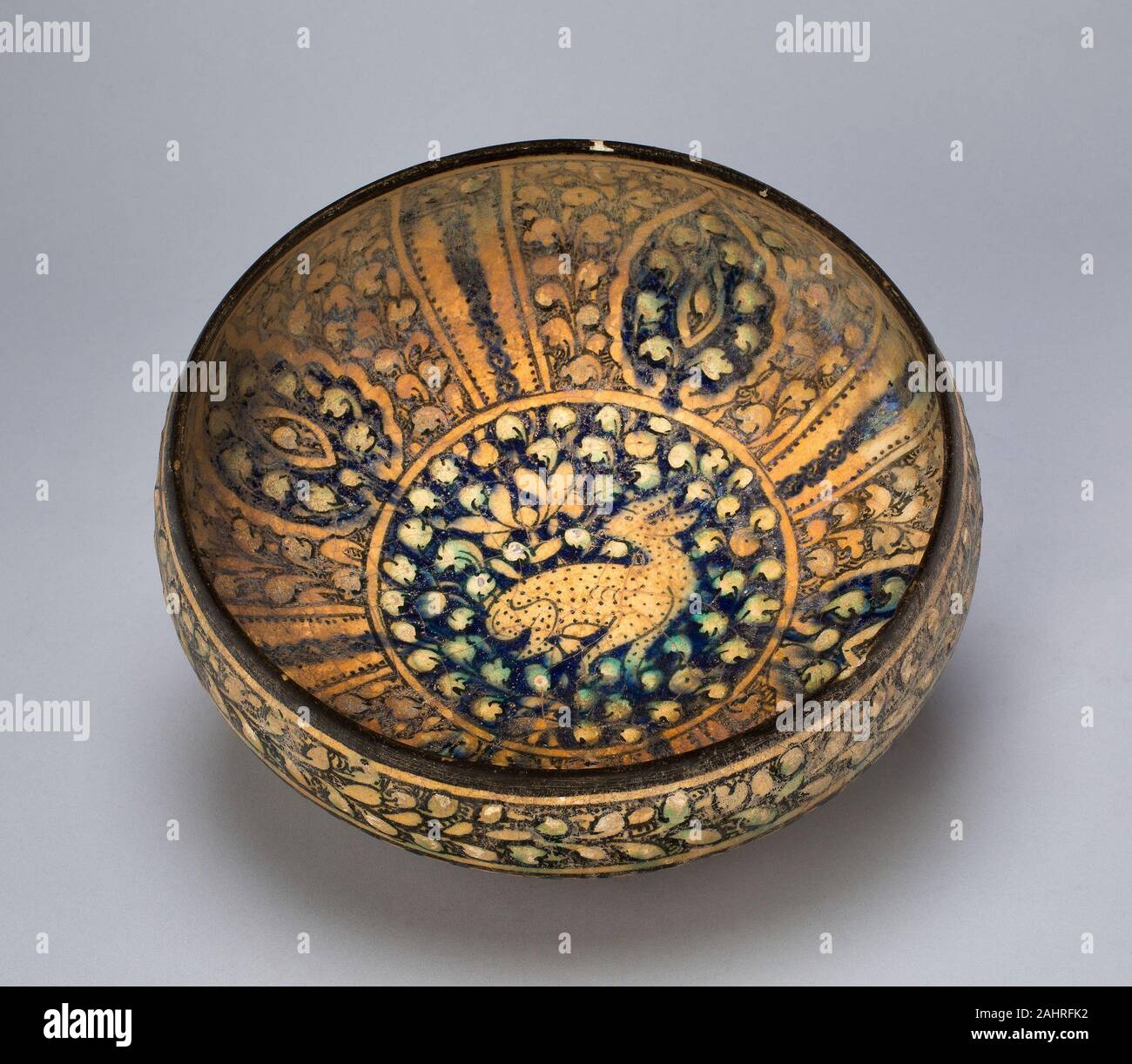 Islamique. Bol. 1260-1400. Sultanabad. Fritware-décor peint sous glaçure, Sultanabad marchandises étaient connus pour leur style particulier de décoration, à savoir le feuillage non utilisé comme arrière-plan pour une figure centrale plutôt que d'un paysage. Bien que ce navire est typique de Sultanabad wares, il a également fait allusion aux influences chinoises introduites dans le cadre du mongols. La fleur de lotus, un symbole populaire de Chine associé à la pureté, apparaît ici juste au-dessus de l'arrière de l'animal la figure centrale. Le lotus a été fréquemment représenté dans les contextes islamiques, bien que très probablement sans les riches associati Banque D'Images