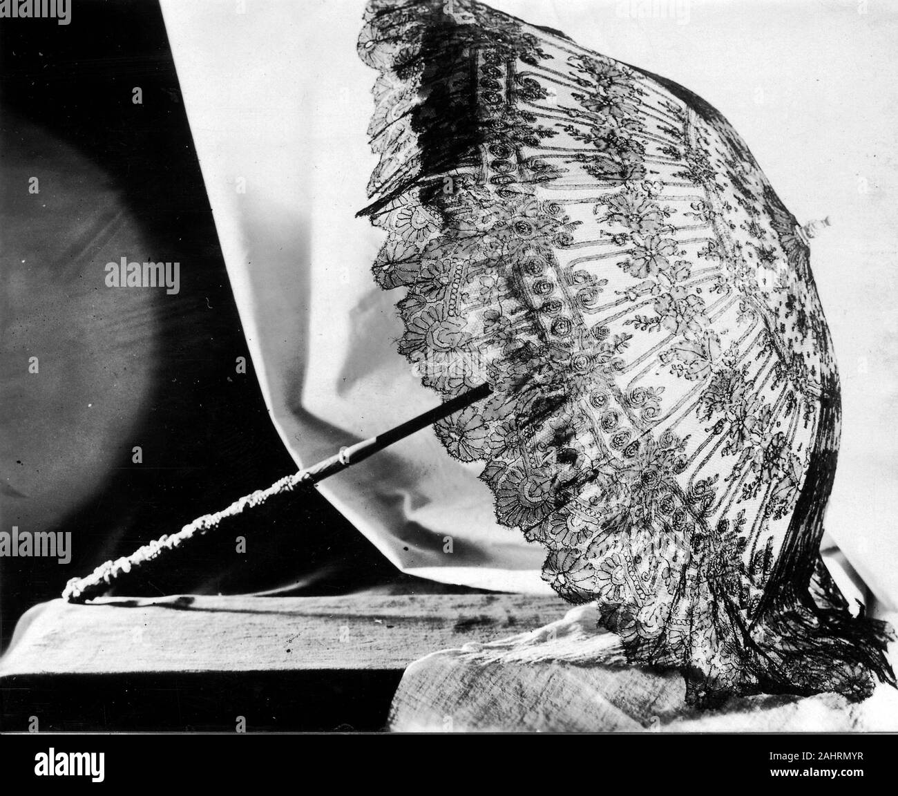 Parasol. 1865-1875. La France. Dentelle Chantilly noire sur fond blanc ; sourate bordée de soie noire fine ; droit poignée en ivoire sculpté avec conception de raisins et de feuilles. Bâti en acier émaillé noir ; tube de fixation moderne Banque D'Images