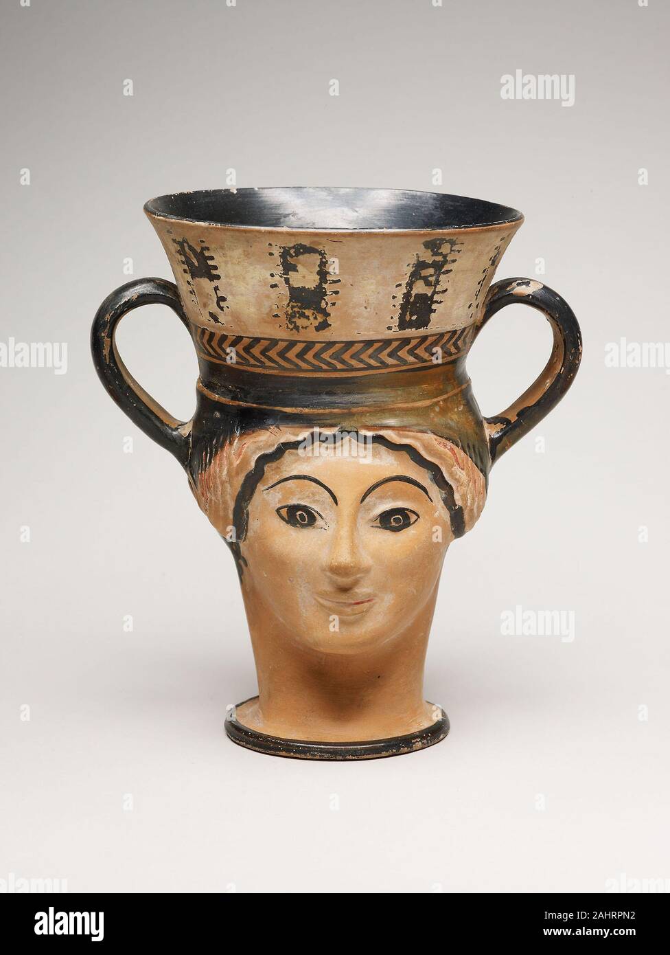 Le grec ancien. Kantharos (coupe de vin) dans la forme d'une femme à la tête. 480 AV. Athènes. terre cuite, rez-de-blanc et noir-figure technique Ceci est un exemple de l'un des plus populaires types de coupe de vin dans la Grèce antique, le kantharos. Cette tasse prend la forme de la tête d'une femme, qui est mis en miroir sur le côté opposé. Passant d'un pied rond, le cou de la femme forme une grande tige, au-dessus duquel la tasse évase à un large bol avec deux poignées sur les côtés opposés. Banque D'Images