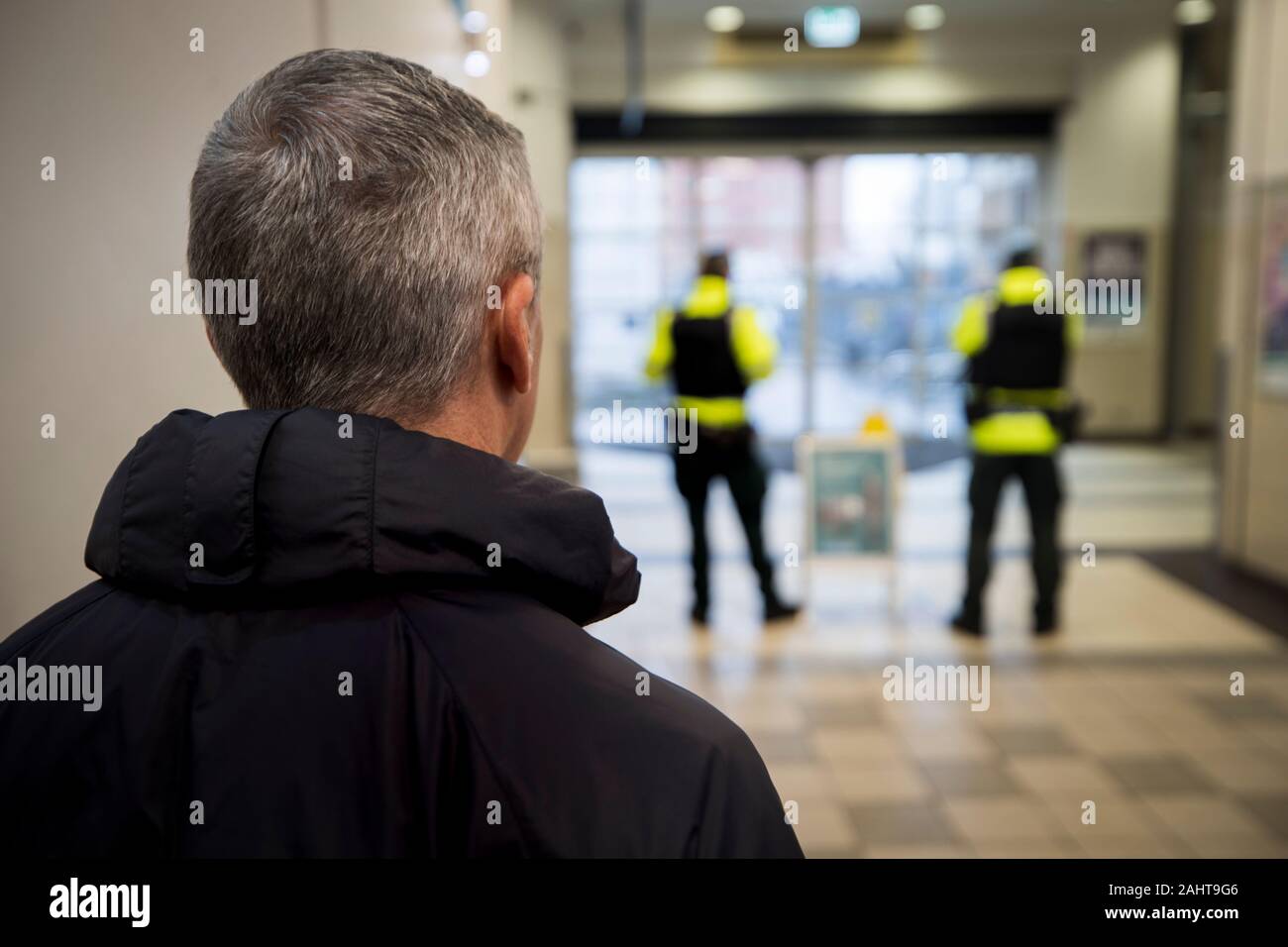 Photo inédit daté du 18/12/19 d'un civil du PSNI regarder deux officiers uniforme à Belfast Europa Buscenter en Irlande du Nord au cours d'une nouvelle patrouille de police à repérer toute activité suspecte. Banque D'Images