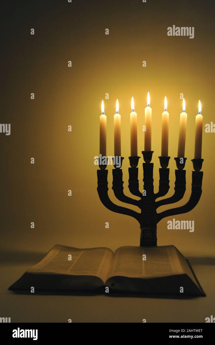 La menorah et bible ouverte avec 7 chandelles isolé sur fond doré. Tir