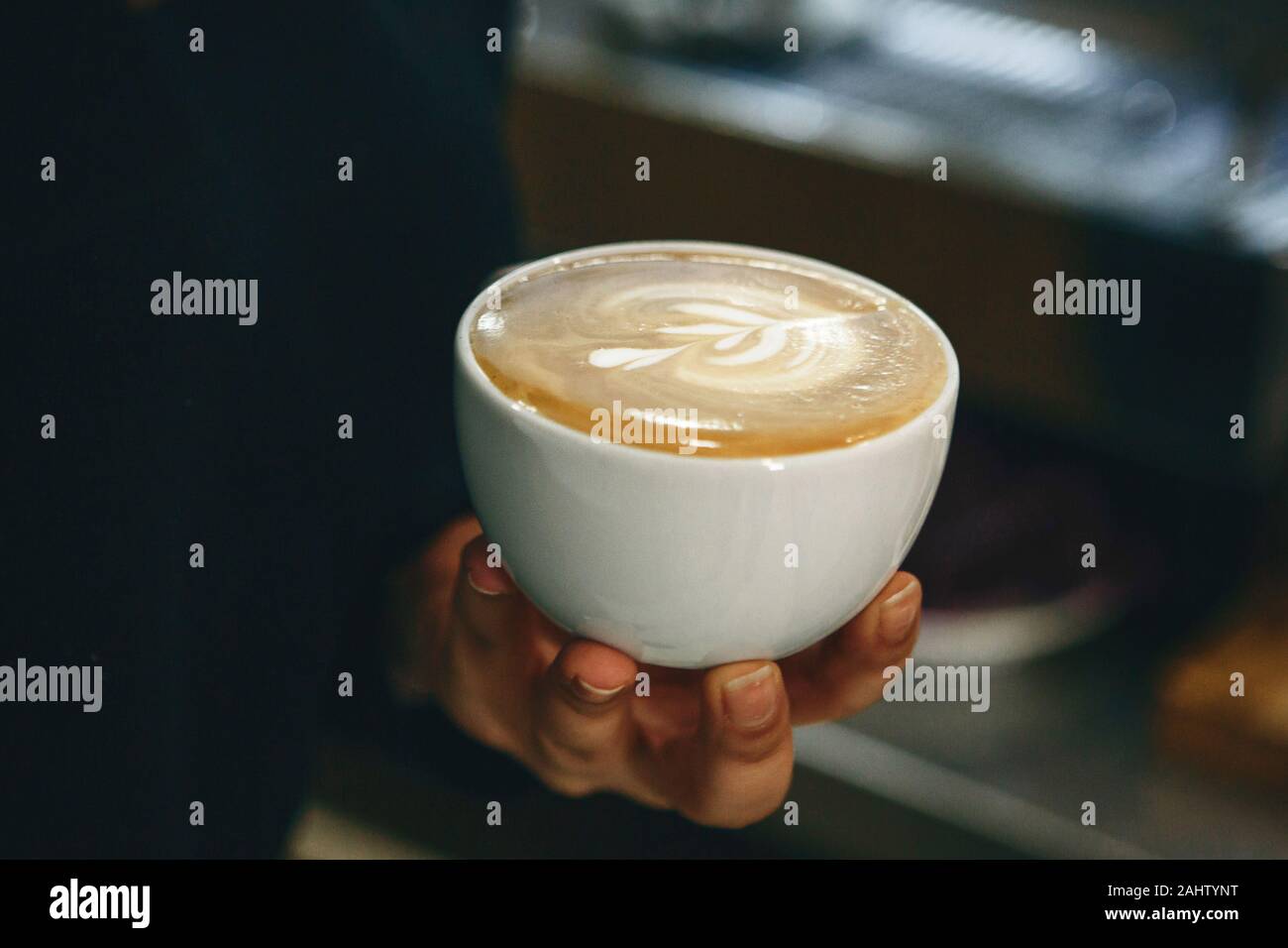 Close-up d'un barista tenant une tasse de café fraîchement moulu à la main. Banque D'Images