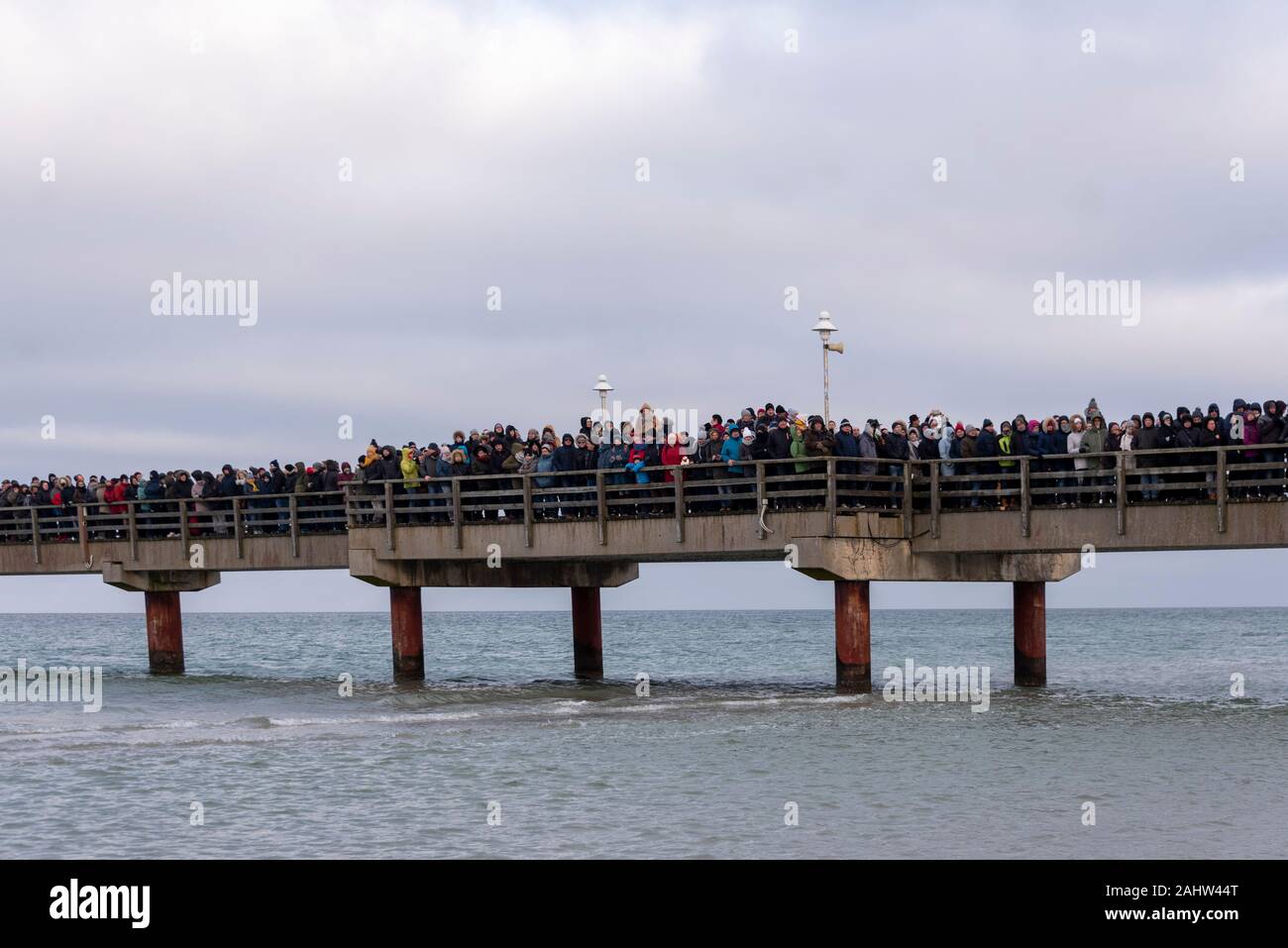 Prerow, Allemagne. 1er janvier 2020. Des milliers de touristes debout sur la jetée de Prerow. Ils regardent les nageurs natation amateur dans le froid de 5 degrés de l'eau de la mer Baltique lors de la traditionnelle baignade dans Prerow. Credit : Mattis Kaminer/Alamy Live News Banque D'Images