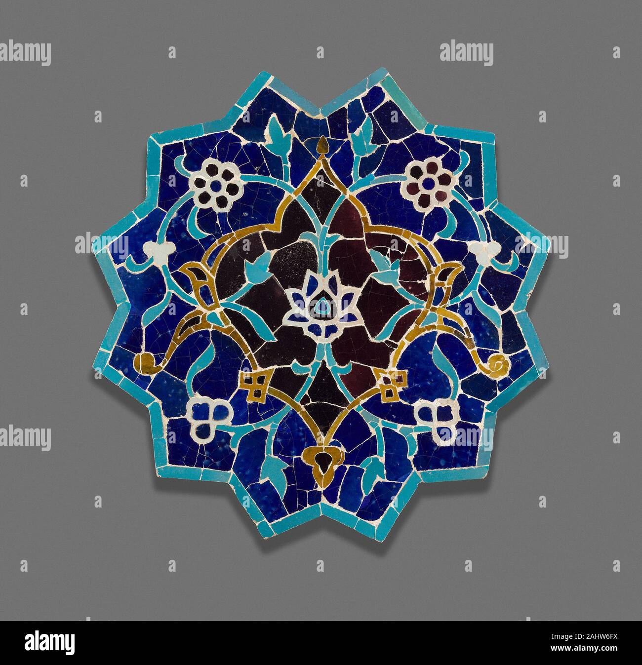 Islamique. Twelve-Point Star. 1450-1499. L'Iran. Fritware vitrés coupe carreaux et remonté comme une mosaïque Ce douze branches est composé de carreaux coupe glacé qui ont été assemblés en une mosaïque. Bien que les mosaïques n'étaient pas rares à cette époque, d'autres étoiles existantes des carreaux de cette période étaient habituellement tirés en une seule pièce. Le schéma de couleurs vives de turquoise et cobalt mettez en surbrillance la mosaïque complexes qui l'de fleurs et de volutes. Une mosaïque comme celui-ci pourrait avoir formé un élément décoratif central sur la chaire d'une mosquée ou il peut avoir orné les murs d'un grand hall, une madrasa ou école religieuse. Banque D'Images