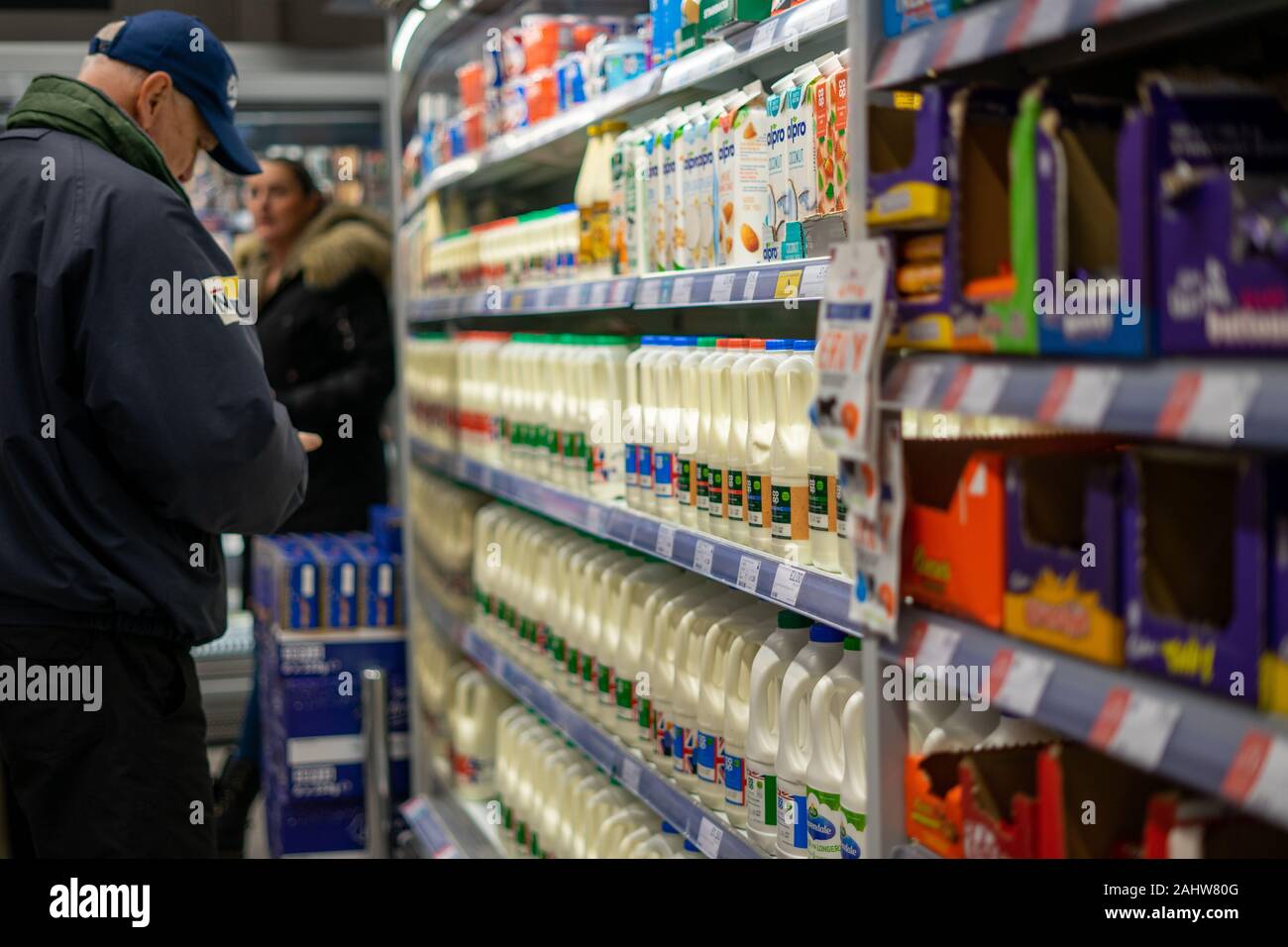 Un homme d'âge moyen dans un supermarché pour acheter du lait ou lait Banque D'Images