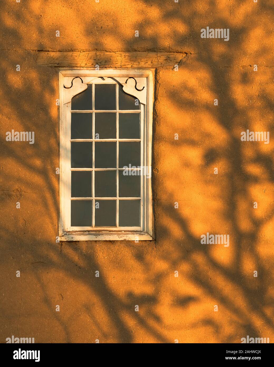 Les ombres des arbres sur la façade et la fenêtre de la chapelle historique de San Miguel sur Old Santa Fe Trail, dans le quartier historique de Santa Fe, Nouveau Mexique Banque D'Images
