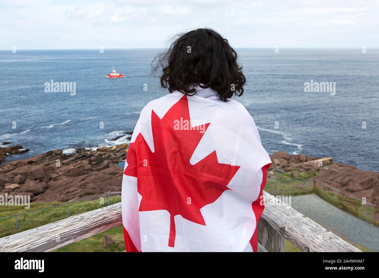 En tourisme d'un drapeau canadien à Cape Spear, à Terre-Neuve et Labrador, Canada. L'emplacement est le point le plus à l'est en Amérique du Nord. Banque D'Images