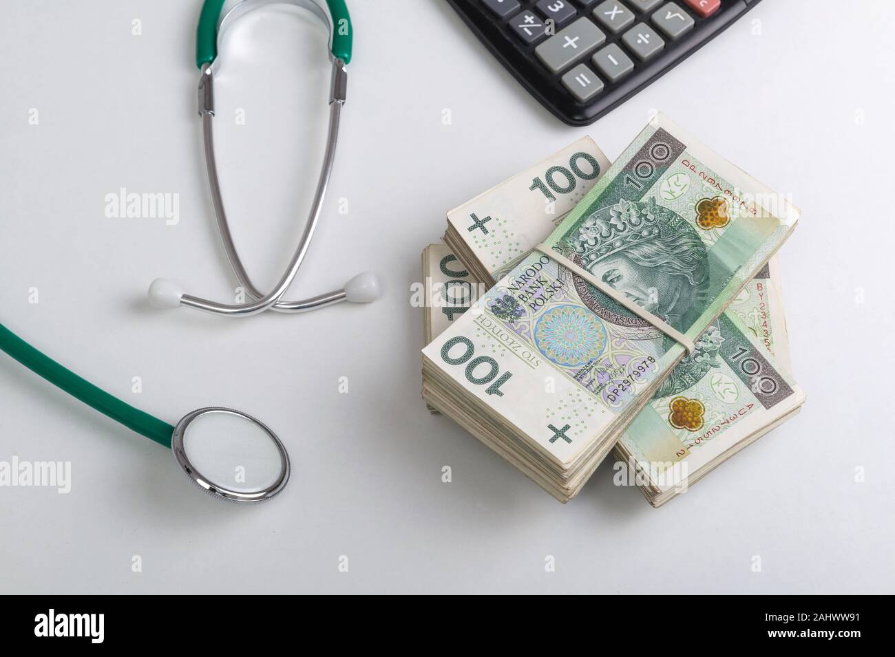Pile de billets d'origine polonaise, stéthoscope et calculateur sur le tableau blanc. Services médicaux concept financier Banque D'Images