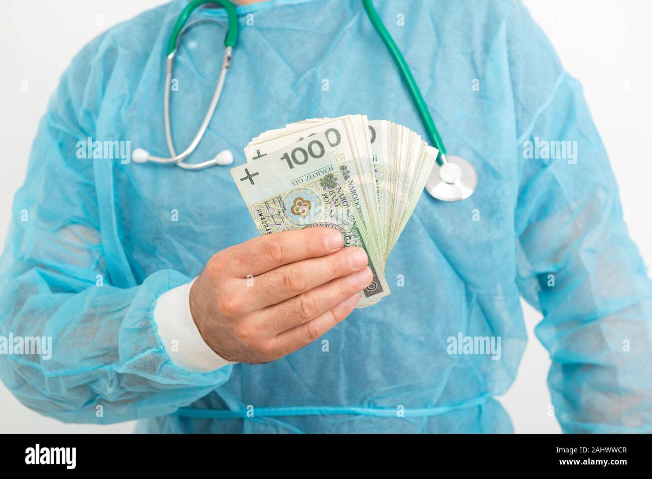 Médecin part holding pile of Polish zloty billets. Services médicaux concept financier Banque D'Images