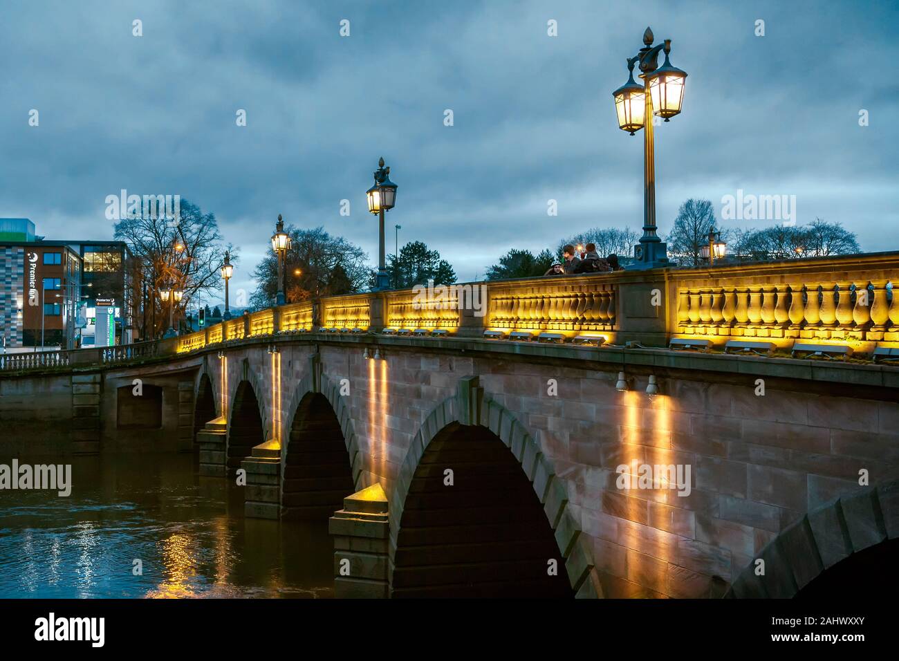 Worcester bridge at Dusk. La lumière des lampadaires de style traditionnel de magnifiques arches du pont et de refléter dans l'eau du fleuve Severn ci-dessous. Banque D'Images
