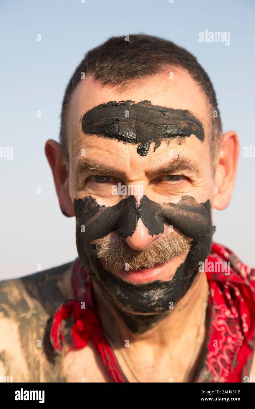 Homme avec de la boue de la mer Morte sur son visage, Israël Banque D'Images