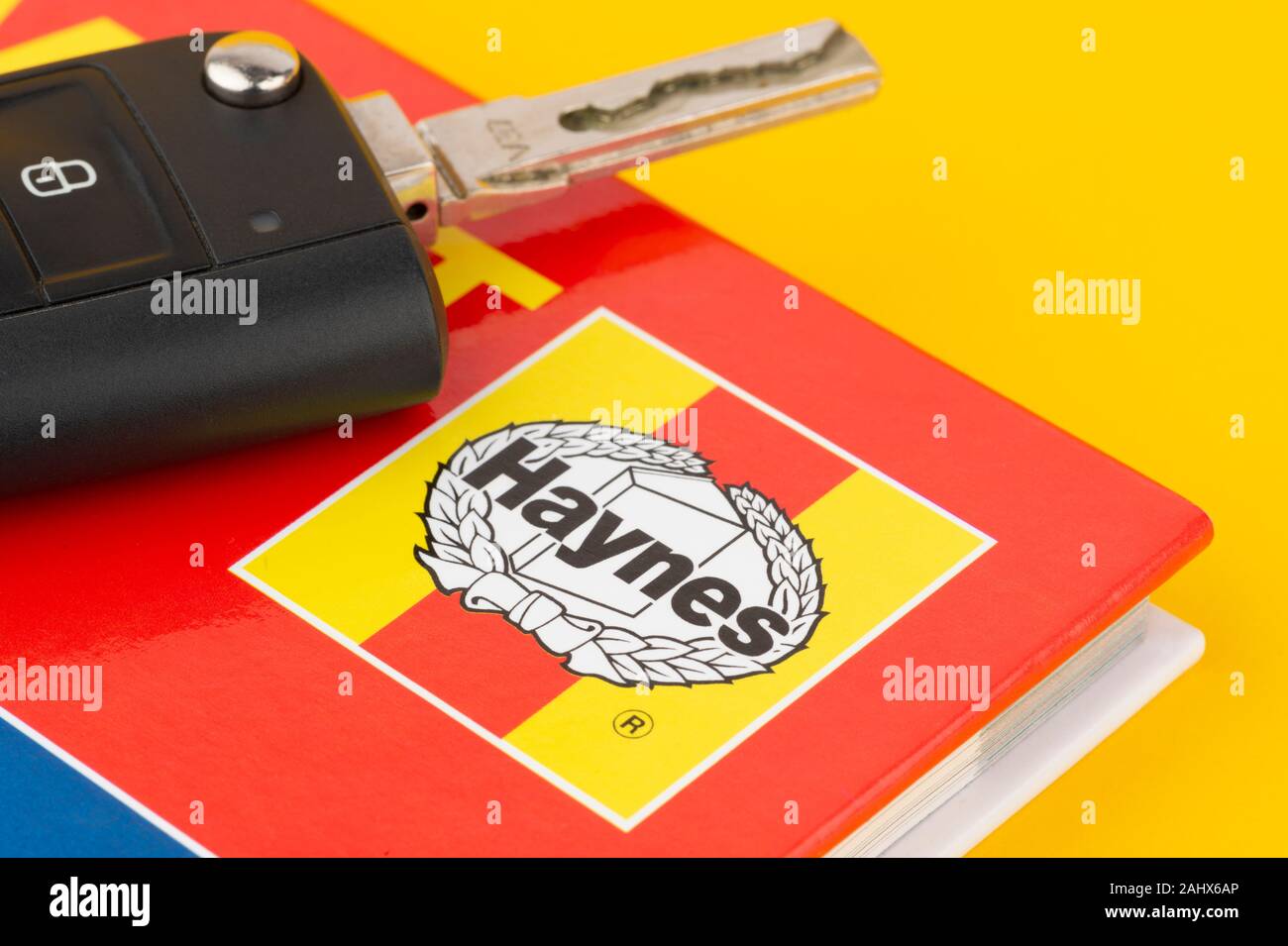 Un manuel Haynes photographiée avec un ensemble de clés de voiture sur un fond jaune. Banque D'Images