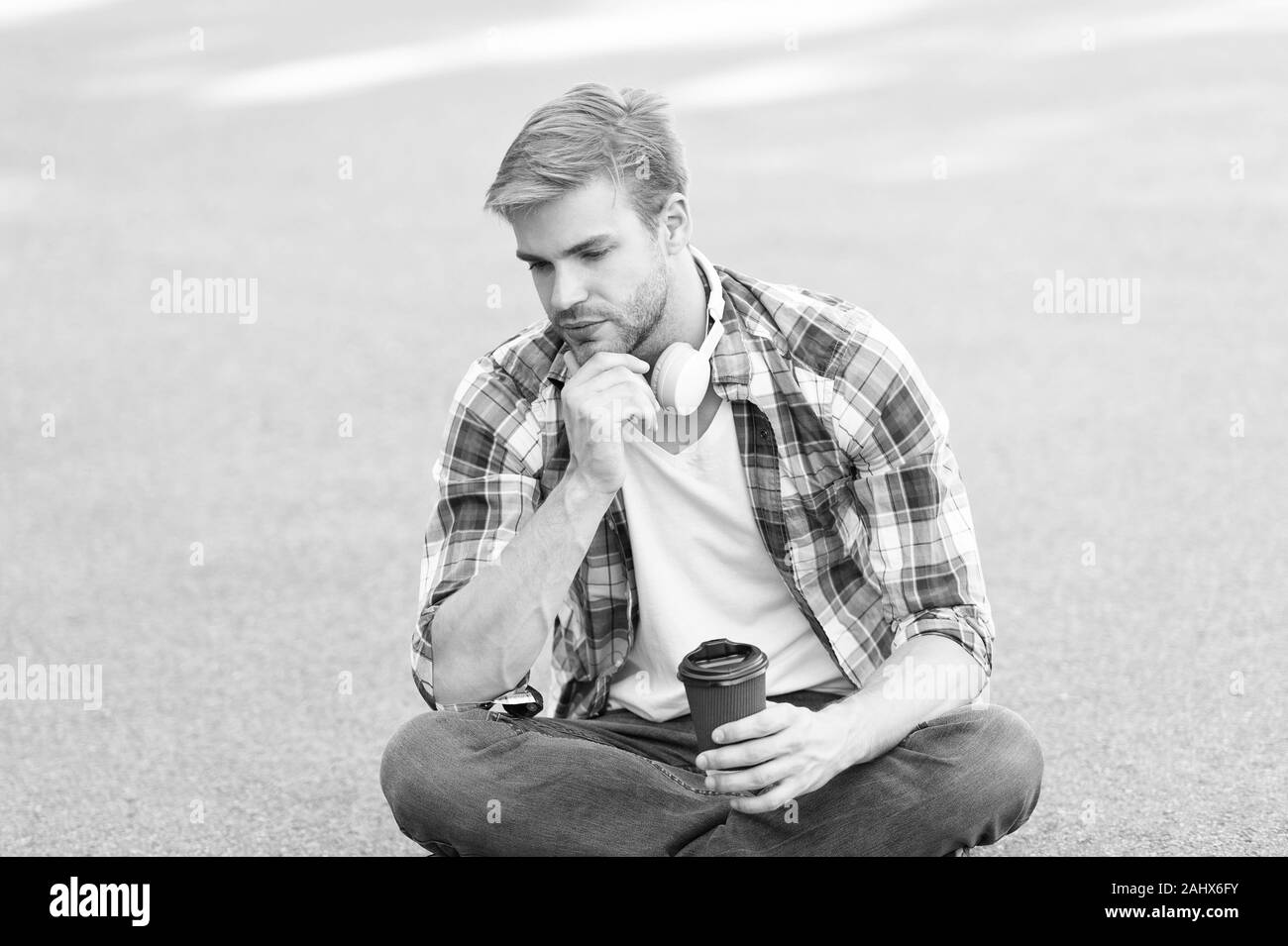 Plus de café. café d'aller. guy boire un café en plein air. L'homme s'asseoir sur le sol. fatigué en étudiant casque. l'éducation en ligne. écouter la musique. ebook concept. homme Chemise à carreaux. élève se détendre et se ressourcer. Banque D'Images